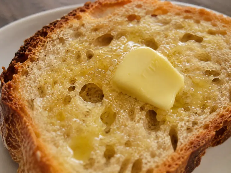 Warm bread with butter melting into the crumb, highlighting texture and aroma.