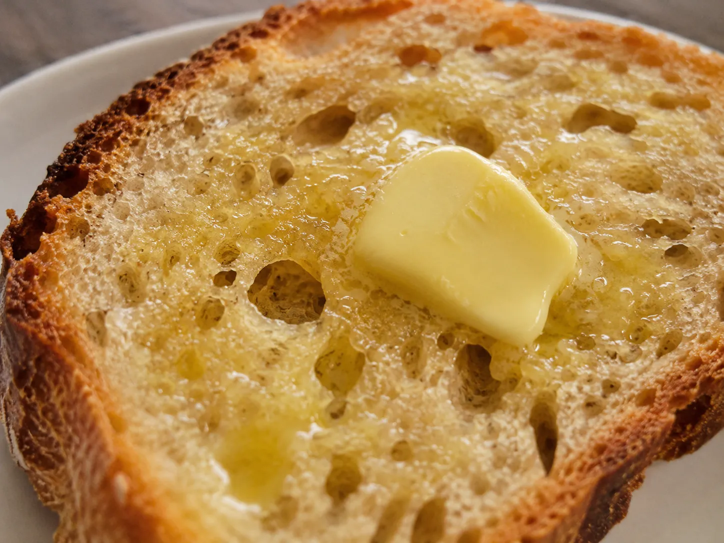 Warm bread with butter melting into the crumb, highlighting texture and aroma.
